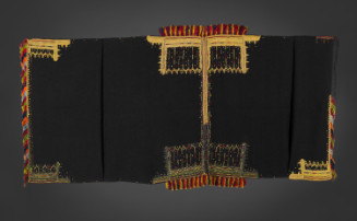 Two panels (handsewn together with red silk) in fine spun wool dyed black with heavy embroidery at the four corners in gold thread, yellow, green, red, blue silk. Embroidered patterning consists of geometric motifs resembling an architectural setting (gables and columns) or a jeweled crown with pendants; along the borders, linking the heavy inlay at the corners are small silk crosses in the above-mentioned colors. Fringes at either end are made of twisted silk threads in red, orange, mauve, gree…