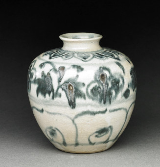 A squat, off-white ceramic jar with a crackled glaze and short neck, decorated with mottled dark green painted floral and abstract loop patterns.