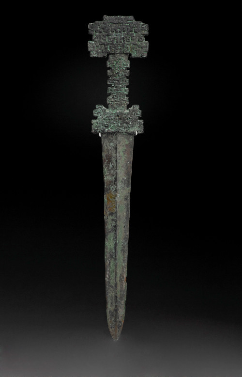 Dagger, cast in one piece, elaborately decorated hilt and pommel and a double-edged blade reinforced with a raised midrib.
