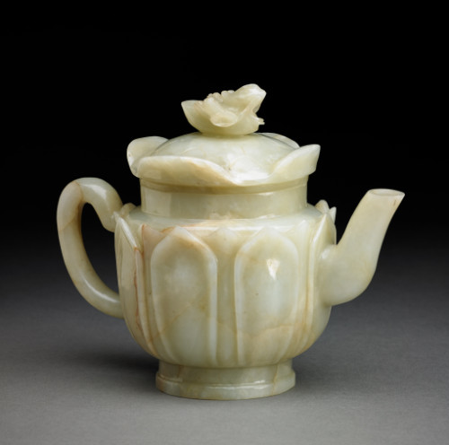 Of tapering globular shape, carved with two layers of eight lotus petals rising from the shallow, pedestal foot, with angular spout, curved handle and plain, straight-cut neck rising from the rounded shoulder, the cover carved as a lotus pad with a four up-turned leaves centered by a mandarin duck holding a lotus spray in its beak, some russet flaws and pale inclusions