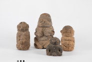 A group of four rough-textured sculptures of figures.