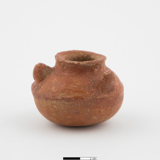 Small jar with small flattened area on otherwise rounded bottom, curving up to outward sloping wall, raised ridge at angle break - 1/2 height inward slope to small raised rim with slight outward flare, three conical nubbins, evenly spaced, on upper wall.  Brown ware with red slip.