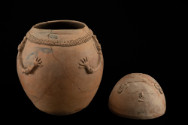 Anthropomorphic urn of ovoid form with modeled features.